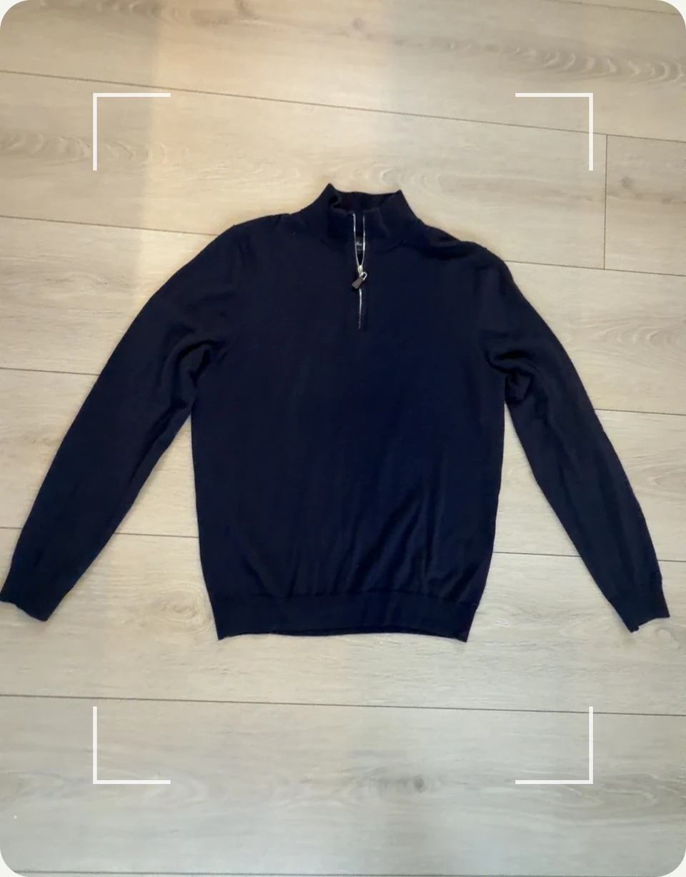 A navy quarter-zip jumper on a wooden floor, framed by Thraed's scan guides